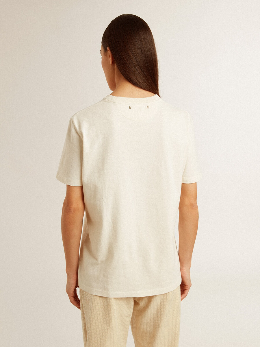 胸にロゴが入った、古びたホワイトのレディースtシャツ