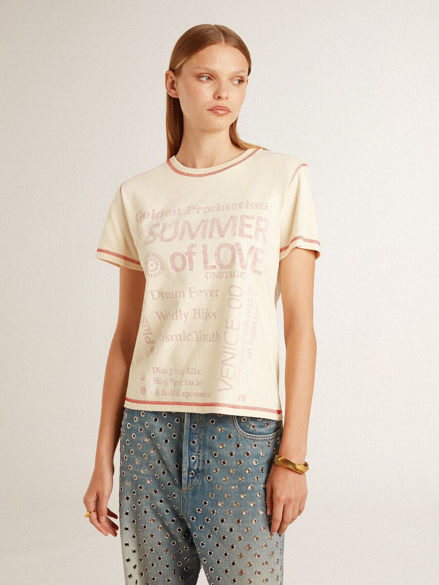色あせた赤のアクセントが付いたクリーム色のレディースtシャツ